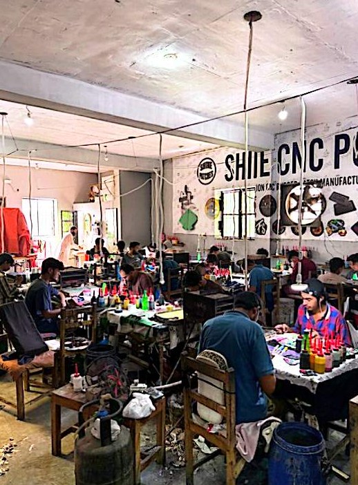 Busy production floor under the Shine wall