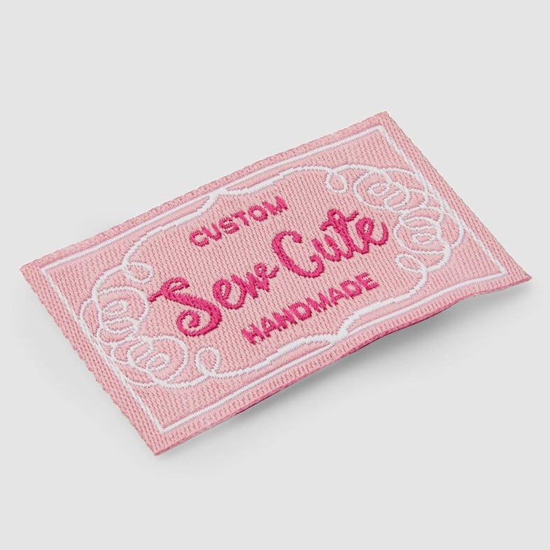 Pink woven label reading Custom Sew Cute Handmade
