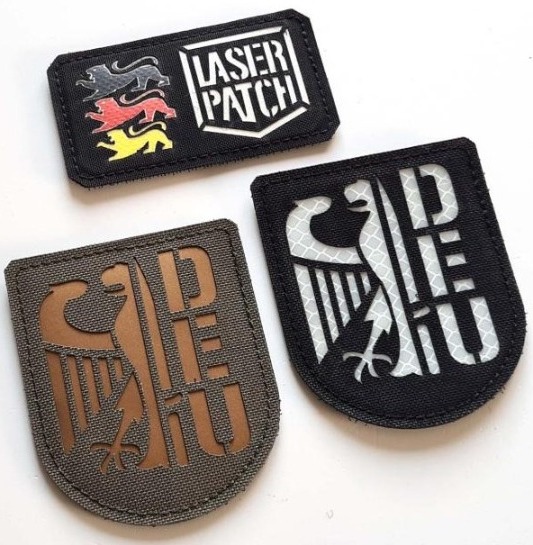 Three laser-cut patches with eagle and lettering designs